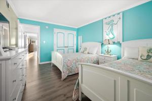 大洋城的住宿－Oceanfront 2 Bedroom Modern Beach Condo w Pool，一间卧室设有两张床,拥有蓝色的墙壁。