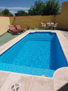 una piscina azul con mesa y sillas en La Casona- BV Hoteles en La Falda
