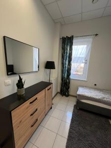 1 dormitorio con tocador con espejo y ventana en Apartamenty Na wzgórzu en Ińsko