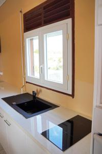 a kitchen with a sink and a window at Loca Vacances in Sainte-Anne