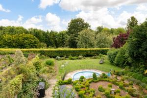 eine Luftansicht auf einen Garten mit Pool in der Unterkunft Downwood Vineyard Manor in Idyllic Countryside in Blandford Forum