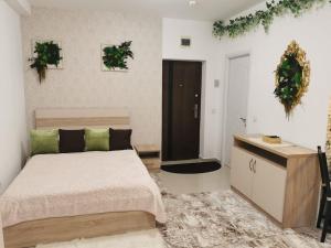 a bedroom with a bed and a desk with plants at Studio Green Modern! in Suceava