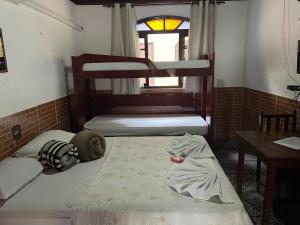 a room with two bunk beds and a table at Pesque pague pousada do Carlinho in Pinheiral