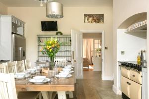 een keuken en eetkamer met een tafel en stoelen bij Downwood Vineyard Manor in Idyllic Countryside in Blandford Forum