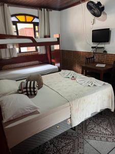 a bedroom with two beds and a tv and a tv at Pesque pague pousada do Carlinho in Pinheiral