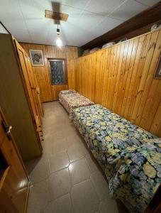 a room with two beds in a wooden wall at Casa Cardillo in Colere