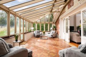 einen Wintergarten mit Glasdecke und ein Wohnzimmer in der Unterkunft Downwood Vineyard Manor in Idyllic Countryside in Blandford Forum