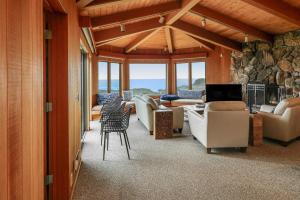 a living room with couches and a stone wall at The Brass Seahorse in Gualala