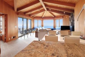 a room with chairs and a living room with windows at The Brass Seahorse in Gualala