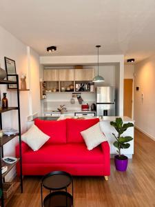 a red couch in a living room with a kitchen at Estudio en Palermo Hollywood in Buenos Aires