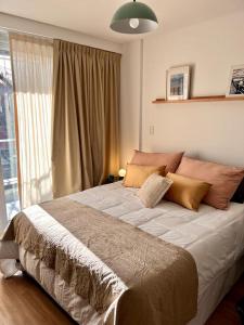 1 cama grande en un dormitorio con ventana grande en Estudio en Palermo Hollywood en Buenos Aires