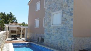 a house with a swimming pool next to a building at Apartments Rustic in Biograd na Moru