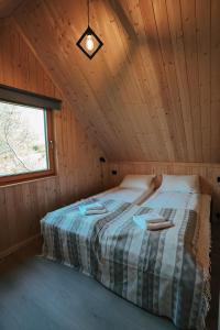 ein großes Bett in einer Holzhütte mit einem Fenster in der Unterkunft Lofoten Cabins in Hopen