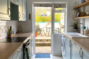 a kitchen with white cabinets and a view of a patio at 2BD Garden Hideaway in Lewes in Lewes