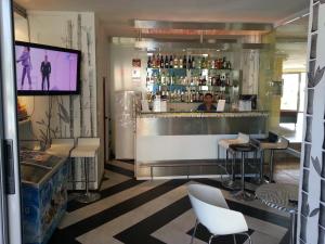 un restaurante con bar y TV de pantalla plana en Marack Apartments, en Sunny Beach