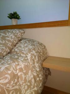 a couch with a pillow next to a wooden shelf at Apartamento A Cabana II in Porriño