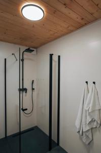 ein Bad mit einer Dusche und Handtüchern, die an einer Wand hängen in der Unterkunft Lofoten Cabins in Hopen