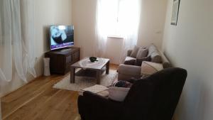 a living room with a couch and a tv at Apartments Rustic in Biograd na Moru