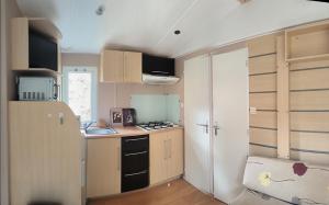 a small kitchen with a sink and a refrigerator at Mira Monti Location in Belvédère +15 photos