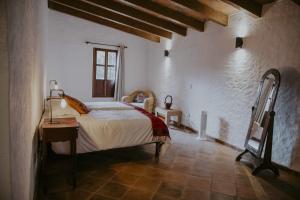 Schlafzimmer mit einem Bett, einem Tisch und einem Fenster in der Unterkunft Hacienda Real San Miguel de Allende in San Miguel de Allende
