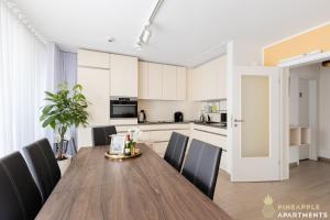 a kitchen and dining room with a wooden table and chairs at Pineapple Apartments Dresden Zwinger IX - 80 qm - 1x free parking - in Dresden