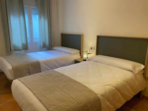 a hotel room with two beds and a window at Apartamento Bronce in Riópar
