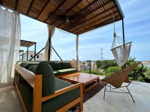 een woonkamer met een bank en een hangmat bij Casa Dakini en la Punta with pool and ocean view in Puerto Escondido