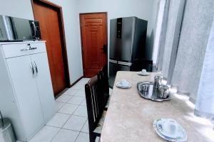 a kitchen with a table with chairs and a refrigerator at Refúgio do Horizonte in Brazópolis