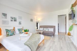 a living room with a bed and a couch at Zzzen aux portes de Paris avec Parking et Netflix in Vincennes +18 photos