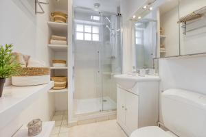 a white bathroom with a shower and a sink at Zzzen aux portes de Paris avec Parking et Netflix in Vincennes