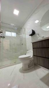 a bathroom with a toilet and a glass shower at Hermosa casa con lujoso rooftop en Cuenca in Cuenca