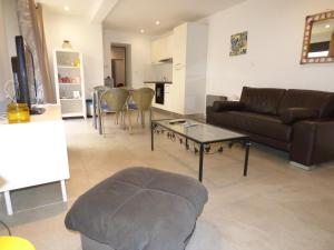 a living room with a couch and a table at "Le Patio"-Meublé de Tourisme 3 étoiles -Résidence "Les Logis de Béziers"-Garage optionnel-Cœur de ville-Plages à 16km ! in Béziers