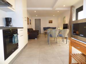 a kitchen and living room with a table and chairs at "Le Patio"-Meublé de Tourisme 3 étoiles -Résidence "Les Logis de Béziers"-Garage optionnel-Cœur de ville-Plages à 16km ! in Béziers