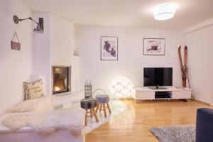 a living room with white walls and a tv at Bungalow Nr. 33 in Altenmarkt im Pongau