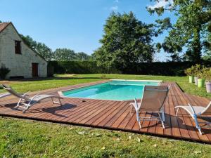 una piscina su una terrazza in legno con 2 sedie di L'Aupinouse Chambre double Chardon, au 1er étage avec salle d'eau privative a La Suze-sur-Sarthe