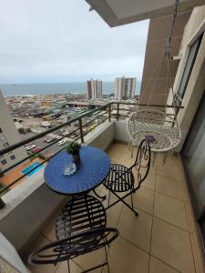 balcón con mesa, sillas y vistas al océano en Disfruta Depto. Antofagasta, en Antofagasta