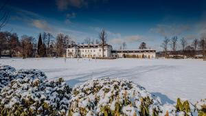 耶莱尼亚古拉Pałac Pakoszów Schlosshotel Wernersdorf的一座大白房子,地面上积雪