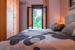 Un dormitorio con una cama grande y una ventana en Edomus Gran Plaza Boutique, en Sevilla