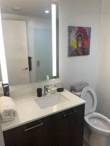 a bathroom with a sink and a toilet and a mirror at Vibrant Studio Downtown Miami in Miami