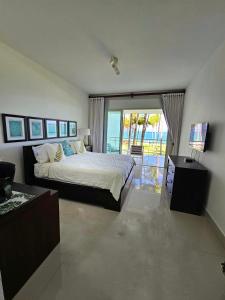 a bedroom with a bed and a sliding glass door at SEAWINDS CABARETE Front beach Condo in Cabarete
