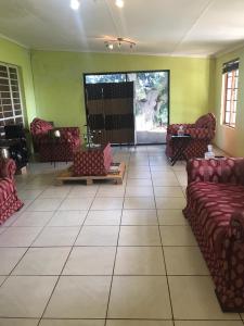 una sala de estar con sofás rojos y una habitación grande con paredes verdes. en Vukaphi Farm, en Cleland