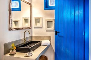 a bathroom with a sink and a blue door at Awe Villa Boutique Trancoso in Trancoso