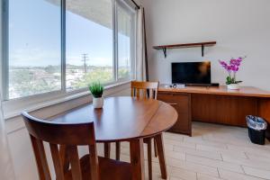 a dining room with a wooden table and a television at Unit 8 Maui Ohana Modern Studio in Wailuku