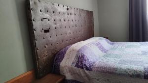 a bedroom with a bed with a metal headboard at Hospedaje Leñas del Tolosa in Las Cuevas