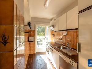 uma cozinha com armários brancos e um lavatório em Parkhouse B201 cosy apartment in De Haan em De Haan