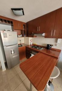 a kitchen with a refrigerator and a wooden counter top at Disfruta Depto. Antofagasta in Antofagasta