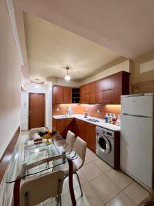 a kitchen with a glass table and a white refrigerator at Apartment in the centre of Yerevan for rent in Yerevan