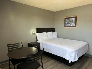 a small room with a bed and a table at Americas Best Value Inn and Suites Groves in Groves