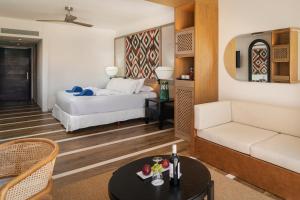 een hotelkamer met een bed en een bank bij Ocean Coral & Turquesa All Inclusive in Puerto Morelos