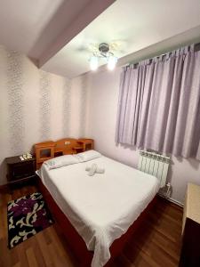 a bedroom with a bed with white sheets and a window at Apartment in the centre of Yerevan for rent in Yerevan +6 photos